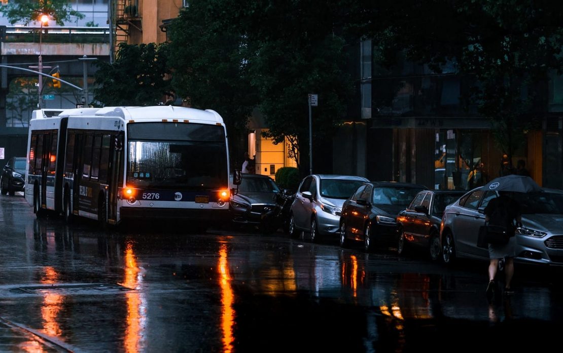 Bus driving on a rainy evening