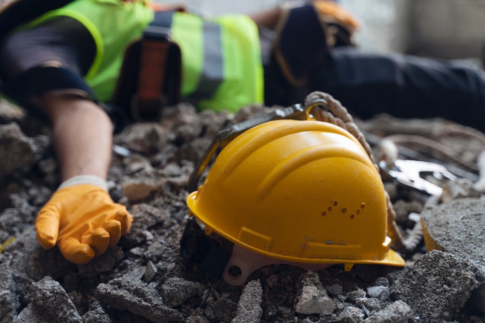 Yellow Construction Helmet On The Ground Next To An Unconscious Worker