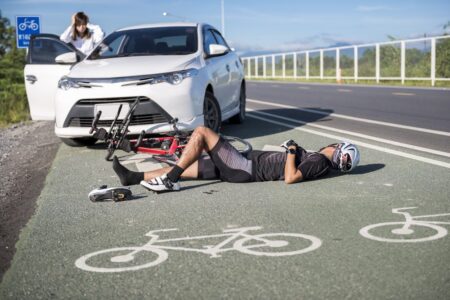 Cyclist Laying On The Road In Front A Car