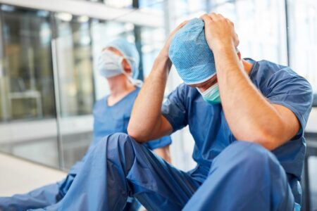 Two Devastated Doctors Sitting On Floor 