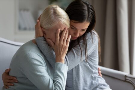 Daughter Hugging Mother Who Is In Pain