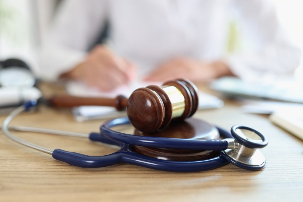 Judges Hammer and Stethoscope On A Table Next To A Doctor